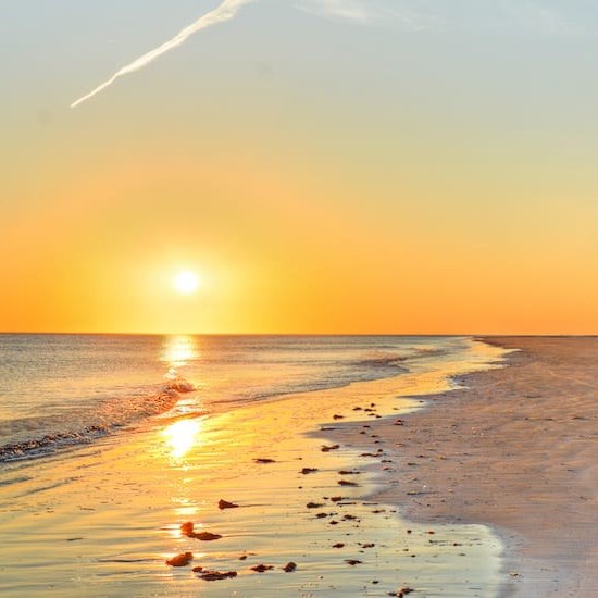Orangene Sonnenuntergangsszenerie am Nordseestrand
